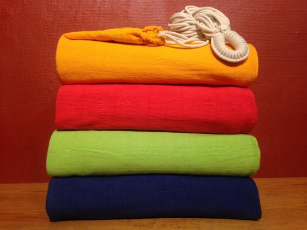 Die Tuchhängematte aus einfarbigem Baumwolltuch in sanftem Orange bietet Komfort für zwei.